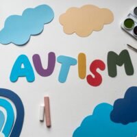 Creative representation of autism awareness with colorful paper cutouts and art materials.